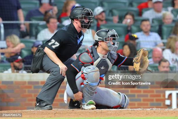 Home plate umpire Austin Jones watches over Miami Marlins catcher Nick Fortes during the Saturday evening MLB game between the Atlanta Braves and the...
