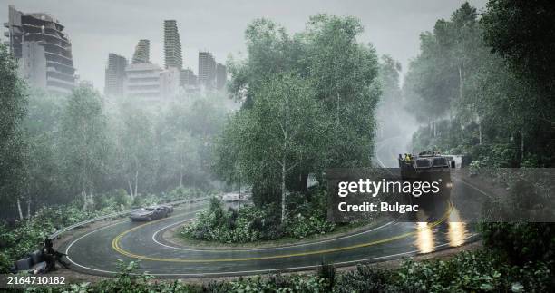 postapokalyptische szene mit verregneter waldstraße und verfallenem stadtbild - militärisches landfahrzeug stock-fotos und bilder