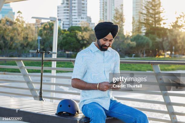 uomo indiano che usa il telefono - guardando il telefono - turbante foto e immagini stock