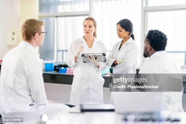 group of scientists working in laboratory having discussion on testing data together. - scientific sample stock pictures, royalty-free photos & images