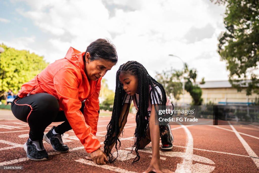 Instructor helping athlete on running track