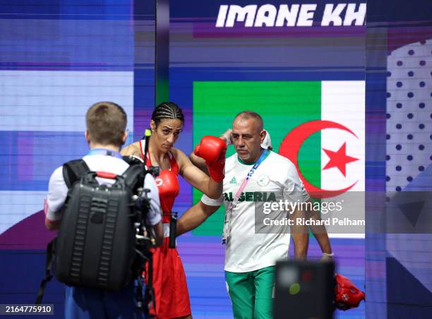 Imane Khelif of Team Algeria makes her way to the ring with Team Algeria Coach Pedro Diaz prior to the Women's 66kg preliminary round match against...