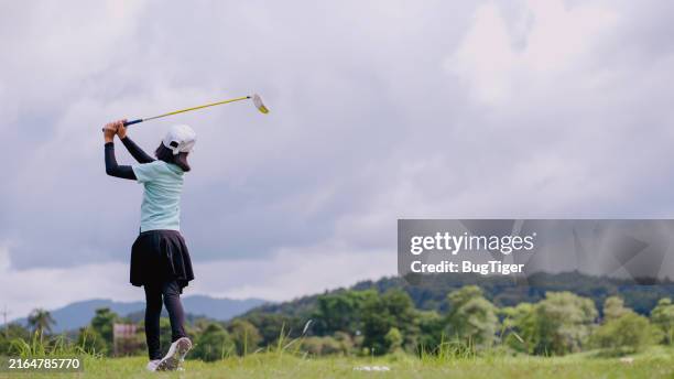 child girl swings a golf club and plays golf in a sand pit in the field. - dusty golf clubs stock pictures, royalty-free photos & images
