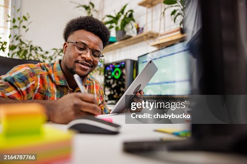 Computer programmer writing notes while coding Computer programmer writing notes while coding