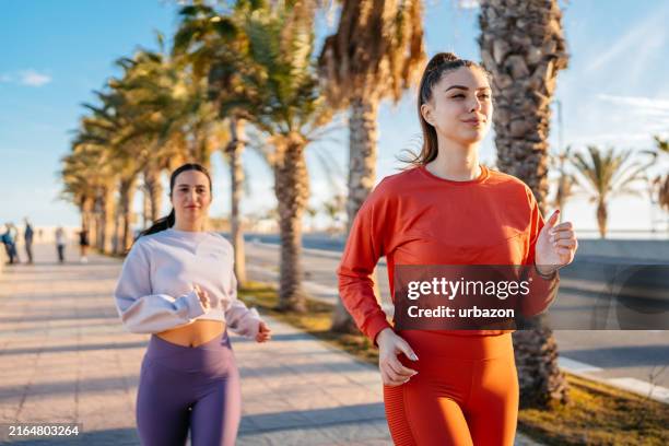 deux amies qui courent à l’extérieur à malaga en espagne - marche sportive photos et images de collection