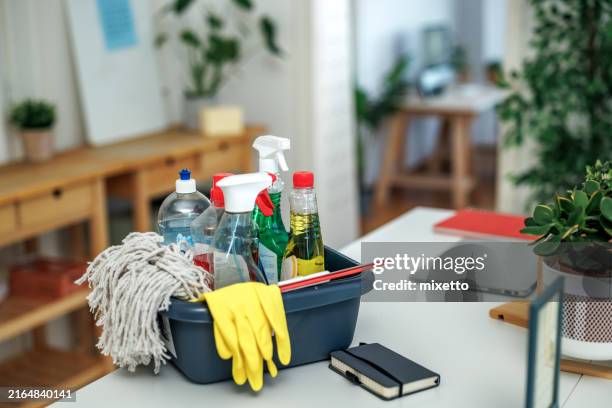 cleaning products on table at small co working space with no people - líquido de limpeza imagens e fotografias de stock