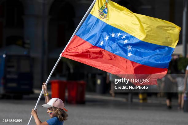 Child is holding the Venezuelan flag during a rally in Praca de Comercio in Lisbon, Portugal, on August 04, 2024. Venezuelans and supporters of Maria...