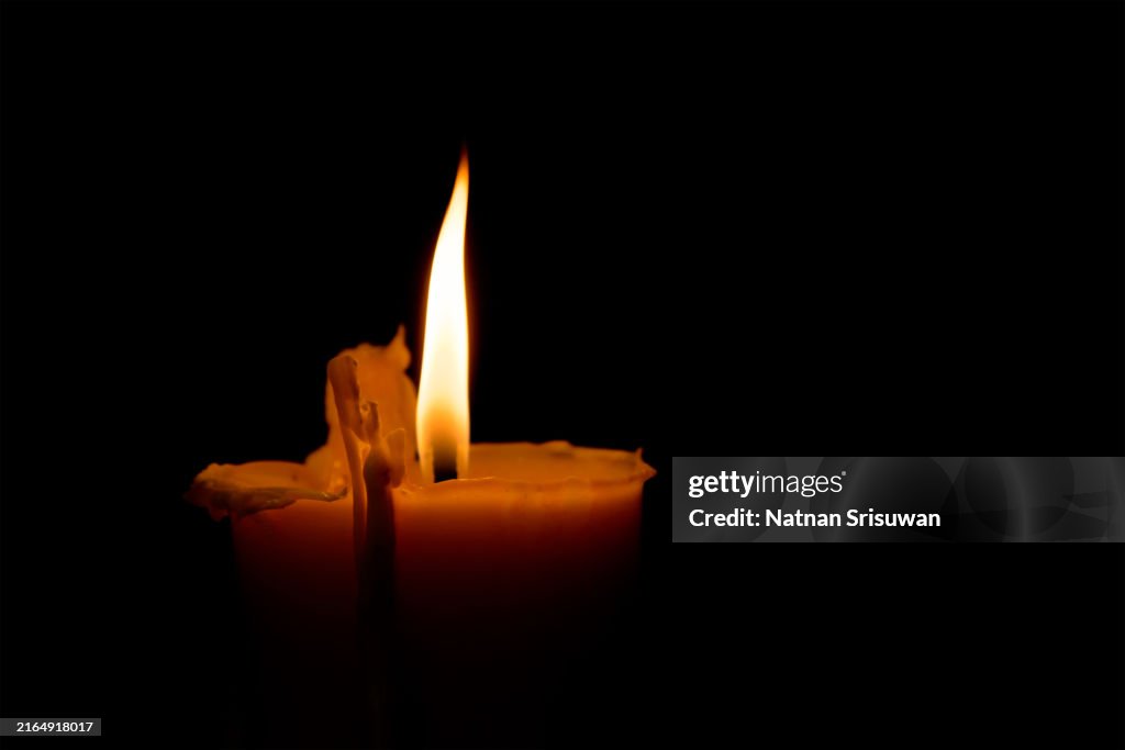 Candle with quite flame on black background