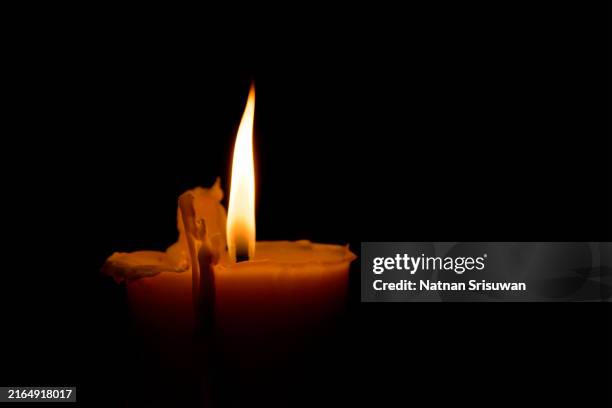 candle with quite flame on black background - mort description physique photos et images de collection