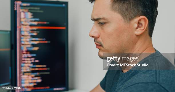 closeup young man software developers using computer to write code application program for ai technology development at desk with multiple screens work at home office. programmer development. - software programmer stock pictures, royalty-free photos & images