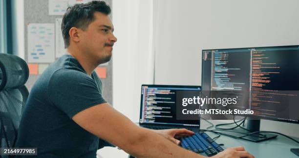 tired depressed bored man software developers using computer to write code application program for ai technology at desk with multiple screens work at home office. programmer development. - work mistake stock pictures, royalty-free photos & images
