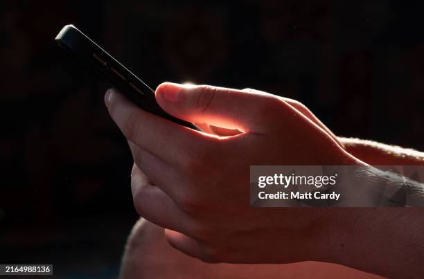 Year-old boy looks at a iPhone screen on July 31, 2024 in Cornwall, England. The amount of time children spend on screens each day rocketed during...