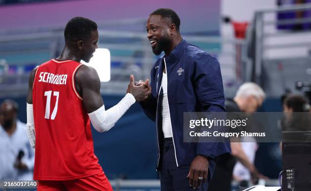 Dennis Schroder of Team Germany talks to former NBA player Dwyane Wade after the Men's Group Phase - Group B game between Team France and Team...