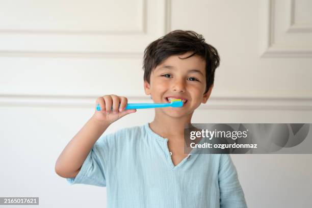 cute little boy is brushing his teeth with a toothbrush - human teeth stock pictures, royalty-free photos & images