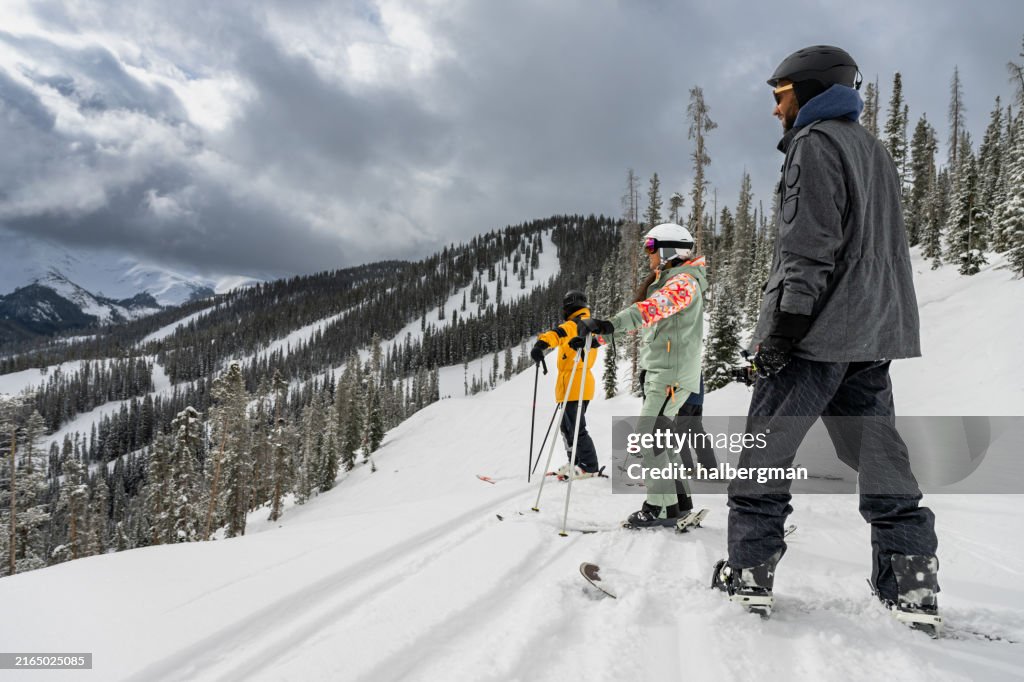African-American Snowboarder Wearing Sunglasses Looking Out at the View