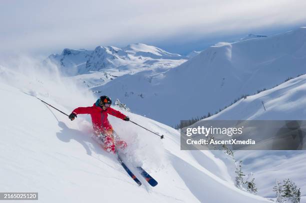 skier skis down slope through fresh powder snow - skieur ou skieuse photos et images de collection