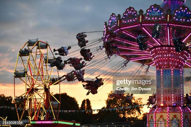 Festival goers enjoy fairground rides at sunset during Wilderness Festival 2024 at Cornbury Park on August 02, 2024 in Charlbury, Oxfordshire.