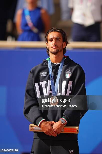 Summer Olympics: Team Italy Lorenzo Musetti in action, stands on the podium after winning the Bronze medal in the men's singles event at Roland...