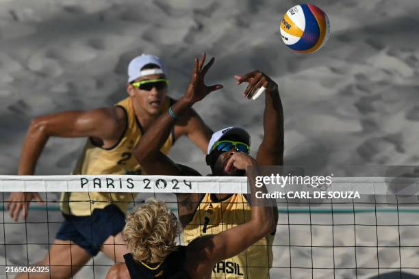 Sweden's David Ahman and Brazil's Evandro Goncalves Oliveira Junior fight for the ball as Brazil's Arthur Diego Mariano Lanci watches in the men's...