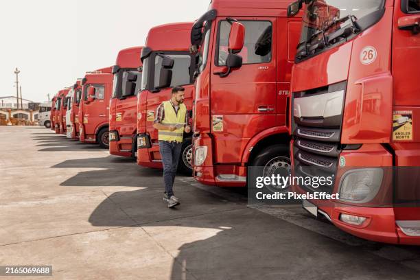 truck driver with digital tablet checking the truck - fleet of vehicles stock pictures, royalty-free photos & images