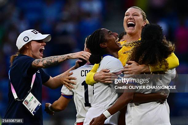 Goalkeeper Alyssa Naeher is embraced by US' defender Naomi Girma and US' defender Casey Krueger as they celebrate after the women's semi-final...