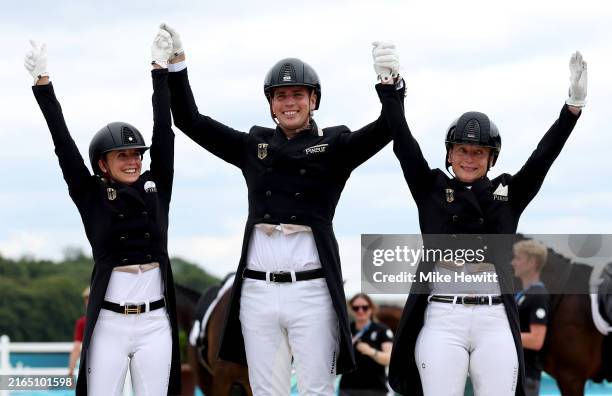 Gold medalists Jessica Von Bredow-Werndl, Frederic Wandres and Isabell Werth of Team Germany celebrate during the medal ceremony for the Dressage...
