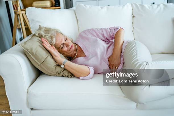 senior woman suffering from stomach pain - bladder stock pictures, royalty-free photos & images