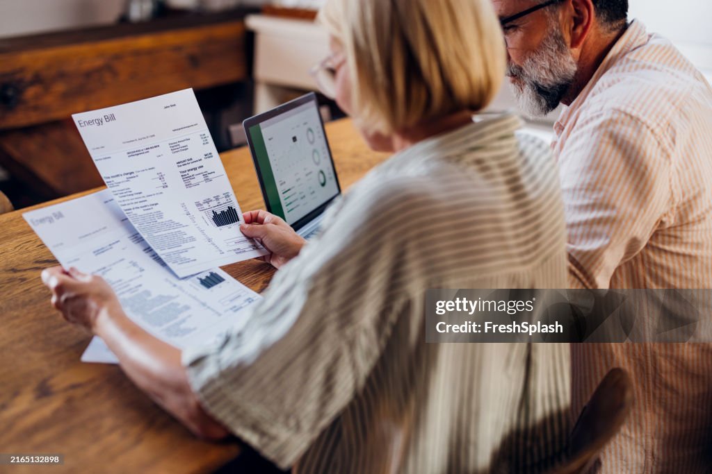Senior Couple Reviewing Energy Bill On Laptop At Home