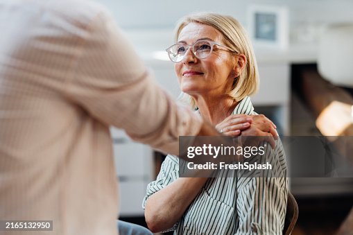 Senior Woman Supported by Male Friend in Modern Home Interior Senior Woman Supported by Male Friend in Modern Home Interior