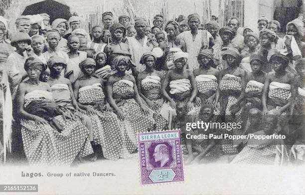 Vintage postcard featuring a large group of native dancers in Lagos, Nigeria, circa 1920.