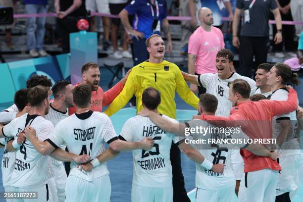 Germany's players celebrate their victory over France at the end of the men's quarter-final handball match between Germany and France of the Paris...