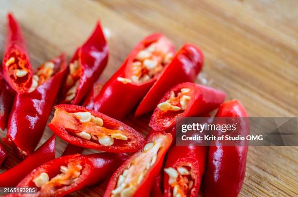 close-up view of chopped red chili pepper on the chopping board - cayenne pepper stock pictures, royalty-free photos & images