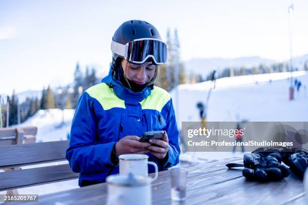 woman texting amidst skiing - skier stock pictures, royalty-free photos & images