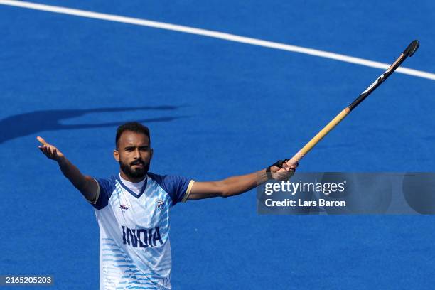 Sukhjeet Singh of Team India celebrates scoring his team's second goal in the penalty shootout past Oliver Payne of Team Great Britain during the...