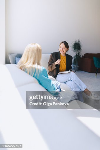 Two women sitting in armchairs and talking. Female coach, psychotherapist, psychologist, advisor and patient, client, job interview Two women sitting in armchairs and talking. Female coach, psychotherapist, psychologist, advisor and patient, client, job interview
