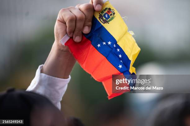 Man waving a Venezuelan flag protesting during a demonstration. Hundreds of Venezuelans living in Madrid protest in Cibeles Square against President...