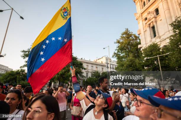 People waving Venezuelan flags protesting during a demonstration. Hundreds of Venezuelans living in Madrid protest in Cibeles Square against...