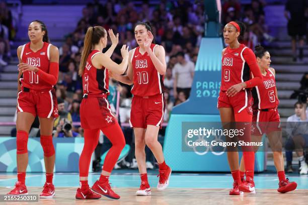 Sabrina Ionescu and Breanna Stewart of Team United States high five while Napheesa Collier and A'Ja Wilson of Team United States look on during a...
