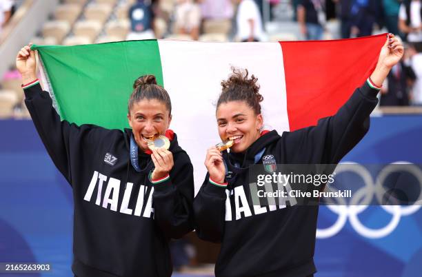 Gold medallists Sara Errani and Jasmine Paolini of Team Italy bite their medals on the podium during the Tennis Women's Doubles medal ceremony after...