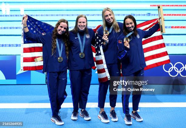 Gold Medalists Regan Smith, Lilly King, Gretchen Walsh and Torri Huske of Team United States pose with the national flag of the United States...