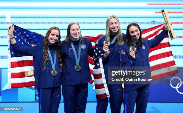Gold Medalists Regan Smith, Lilly King, Gretchen Walsh and Torri Huske of Team United States pose with the national flag of the United States...