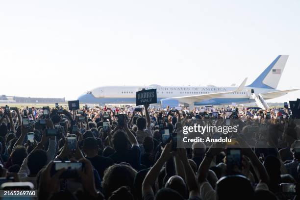 People cheer and hold signs at a campaign rally for Vice President Kamala Harris and her running mate, Tim Walz, in Romulus, MI, on August 7, 2024.