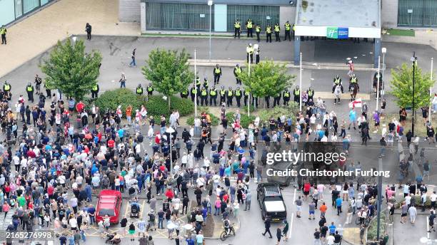 In this aerial view anti-migration protesters stand outside of the Holiday Inn Express in Manvers, which is being used as an asylum hotel, on August...