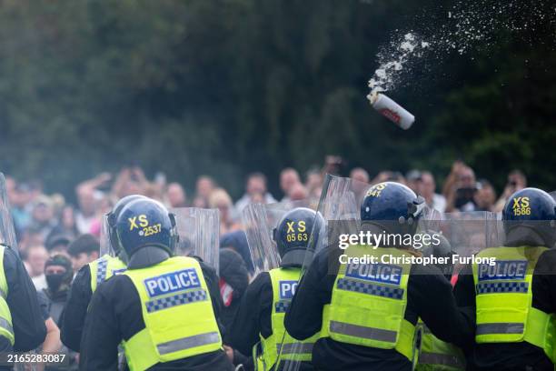 Riot police officers push back anti-migration protesters outside the Holiday Inn Express Hotel which is housing asylum seekers on August 4, 2024 in...