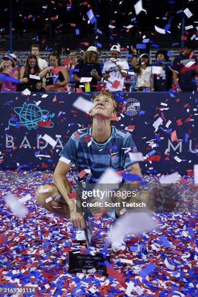 Sebastian Korda of the United States looks through confetti while holding the Donald Dell Trophy after defeating Flavio Cobolli of Italy to win the...