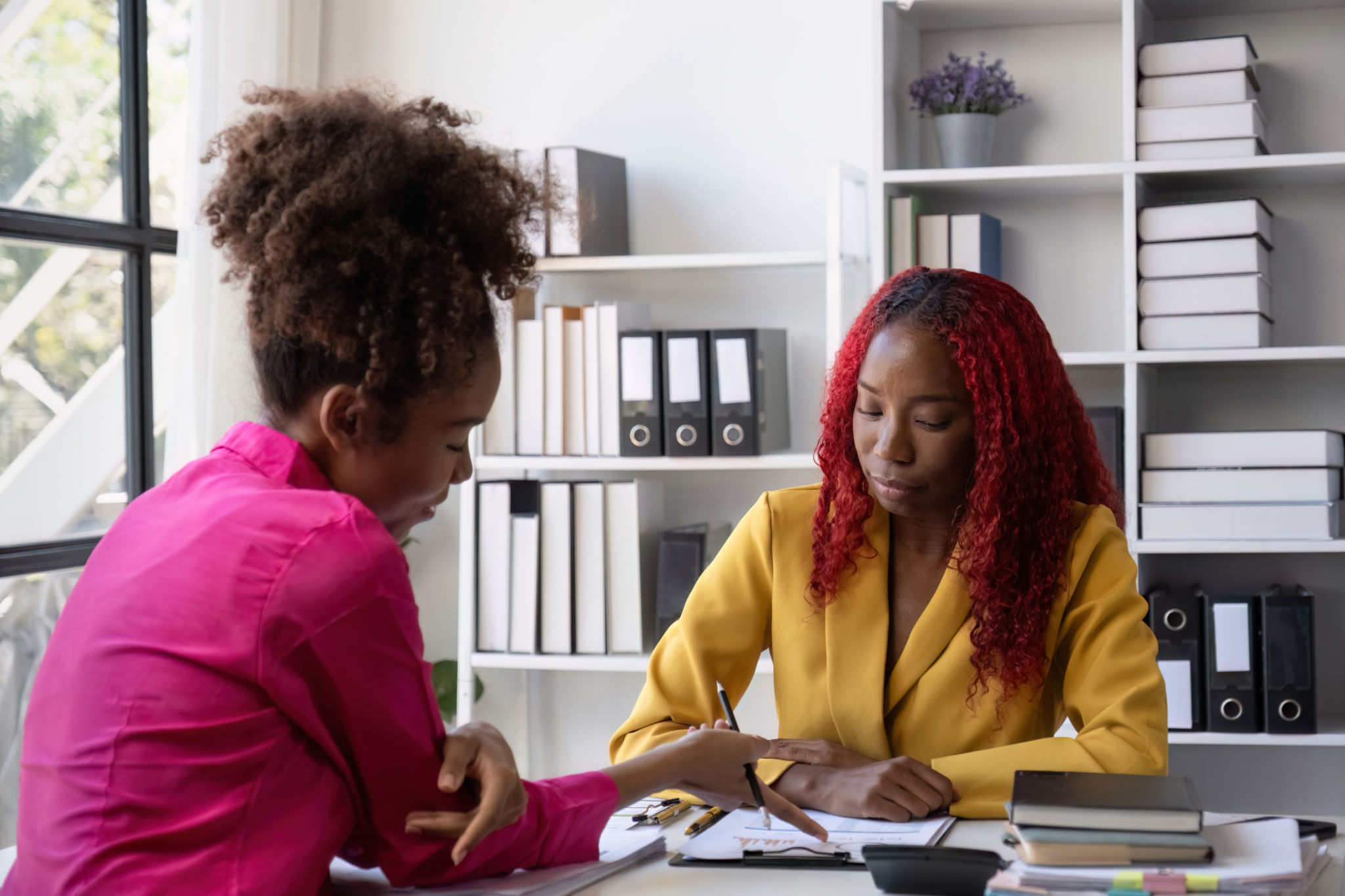 Young African American Business Woman Stressed with Paperwork in Modern Office Setting, Discussing with Colleague Young African American Business Woman Stressed with Paperwork in Modern Office Setting, Discussing with Colleague
