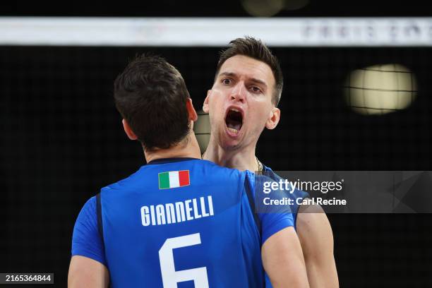 Yuri Romano of Team Italy celebrates with teammate Simone Giannelli after scoring a point during the Men's Quarterfinal match between Team Italy and...