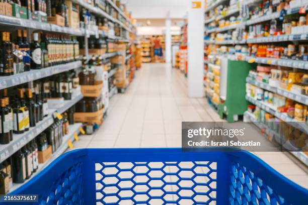 first person view of a shopping cart in the aisle of a supermarket. - stormarknad bildbanksfoton och bilder