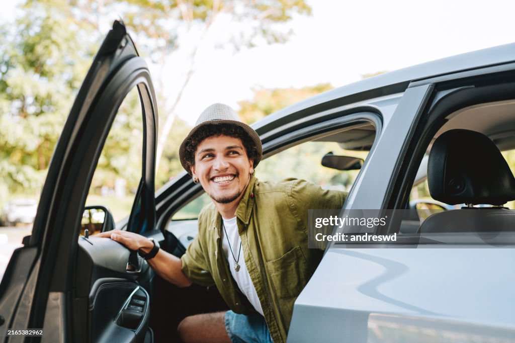 Young man traveling by car getting out of the car