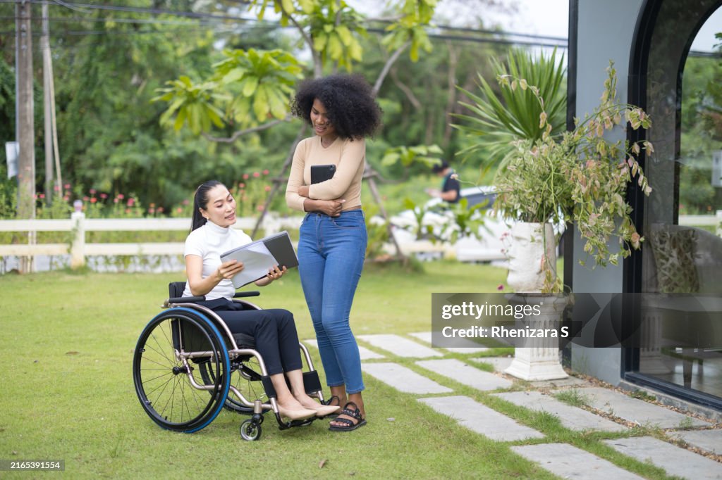 Disable Professional Asian Disabled Woman In A Wheelchair And African Female Engage In A ...